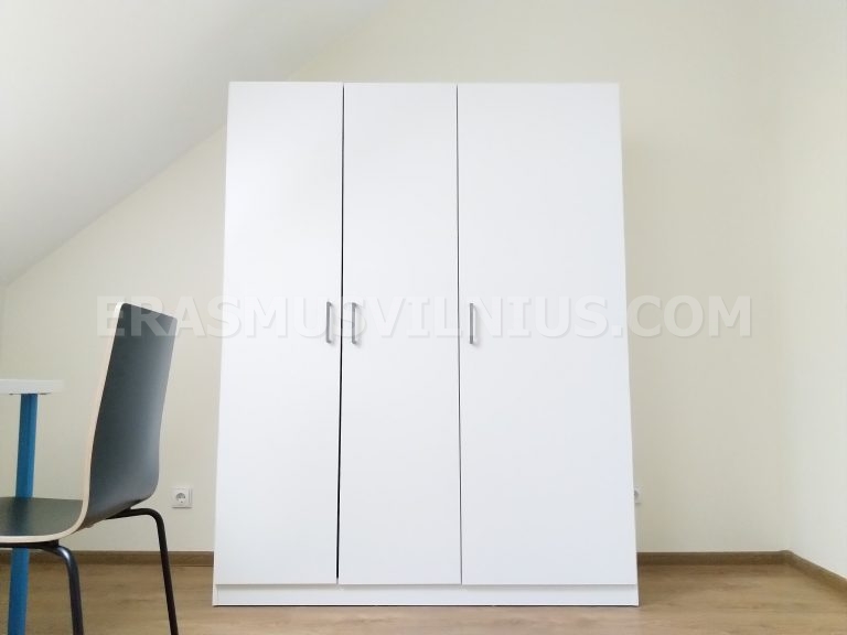 Encimera de cocina con vitrocerámica y utensilios en piso de estudiantes