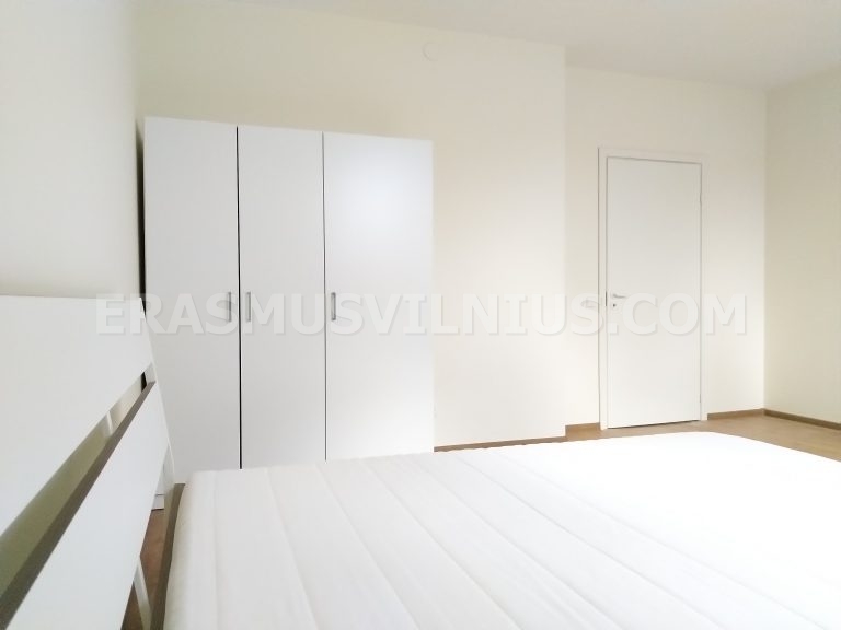 Vista completa del baño con ducha, inodoro y lavabo en piso de Vilna